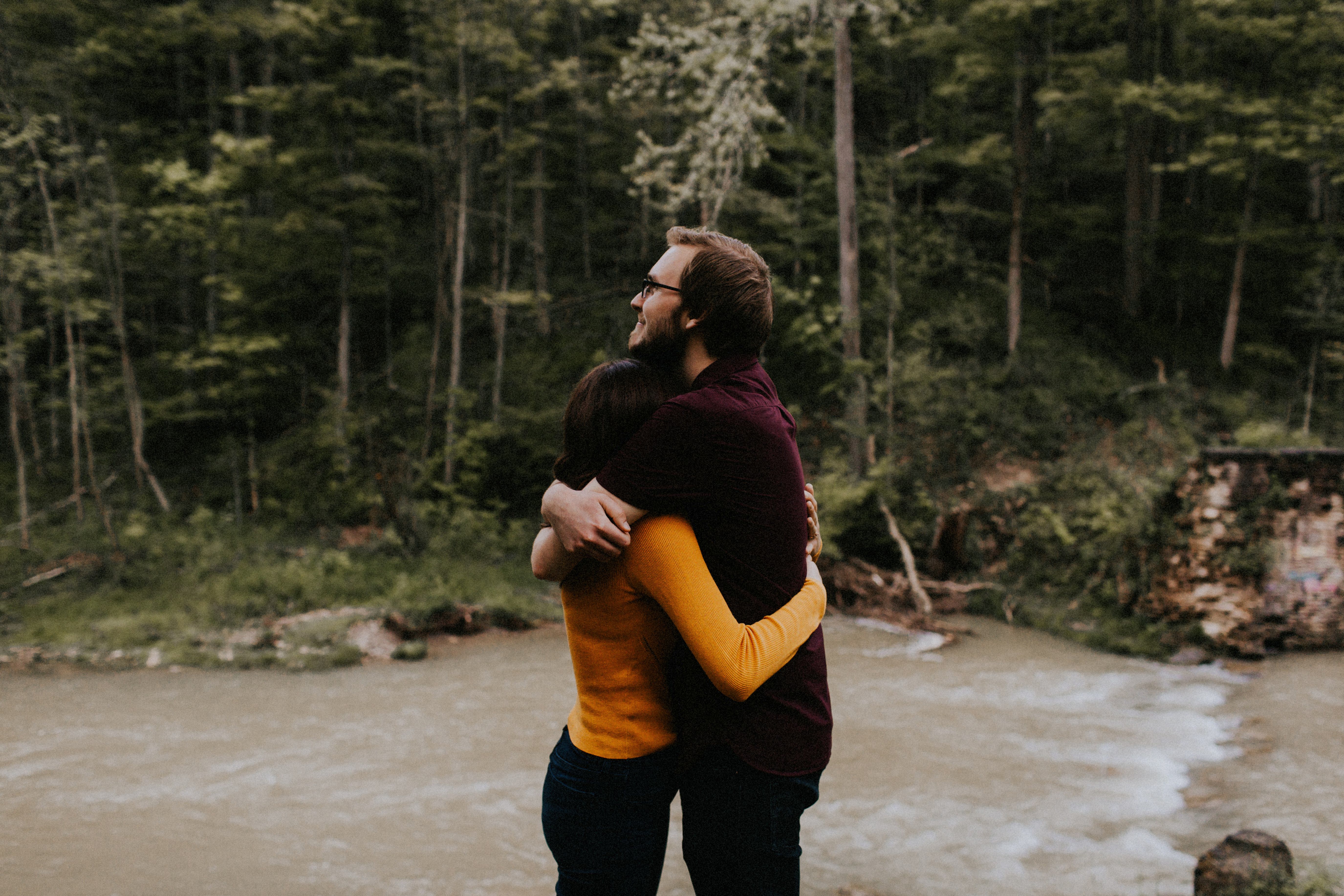 couple hugging by stream