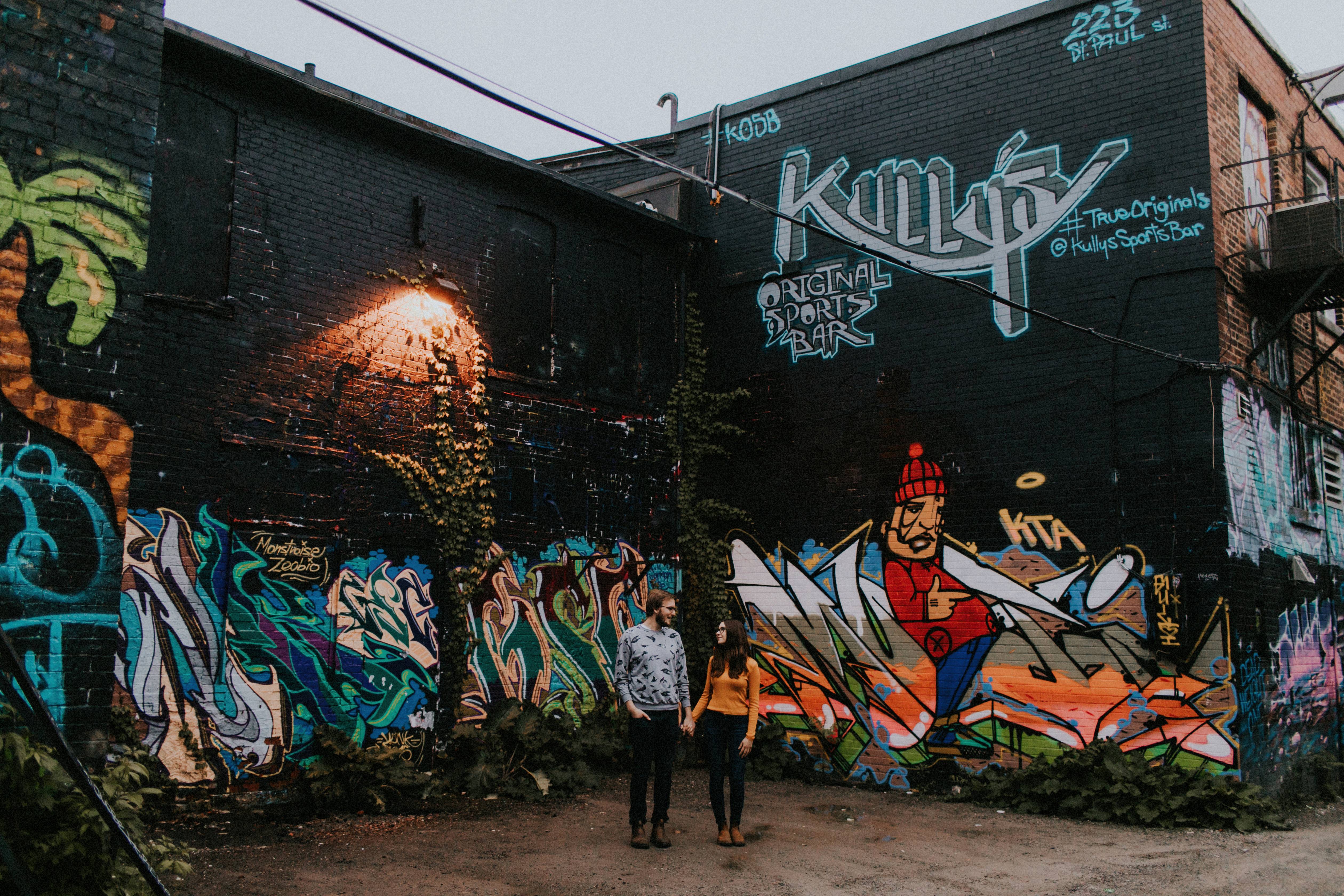 couple standing by graffiti