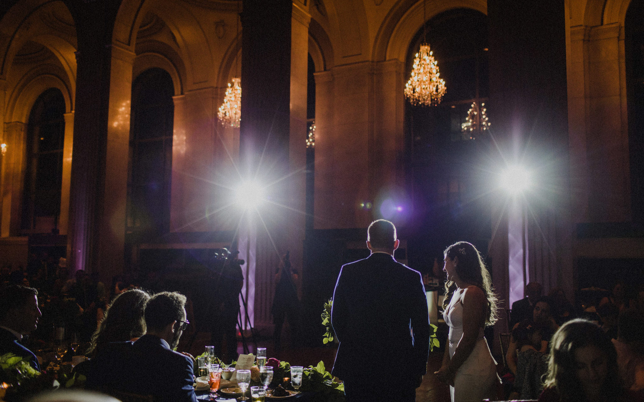 bride and groom give speech in spotlights