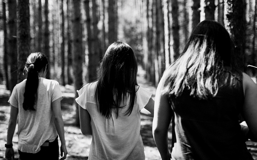 three girls walking into forest