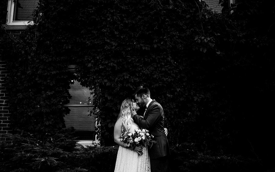 bride groom kiss by ivy wall