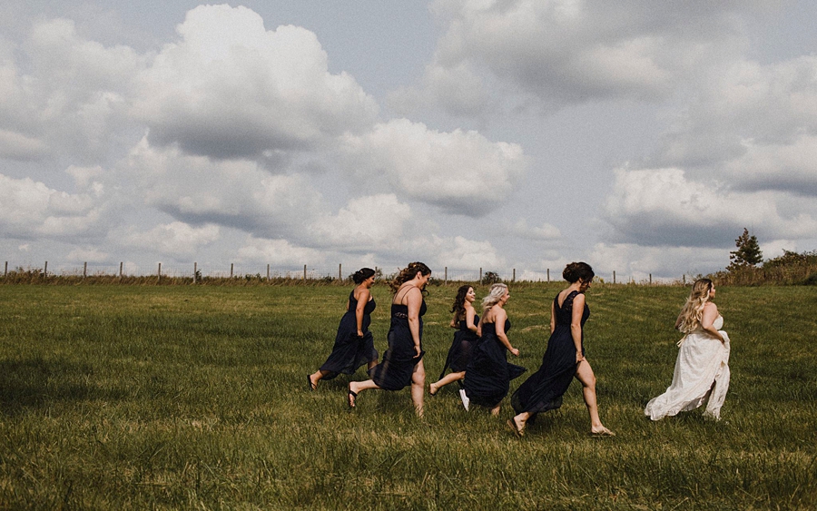 bridesmaids run through wheat fields