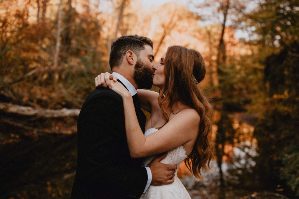 Bride and groom kiss by the river - Autumn Micro Wedding at Berkeley Fieldhouse