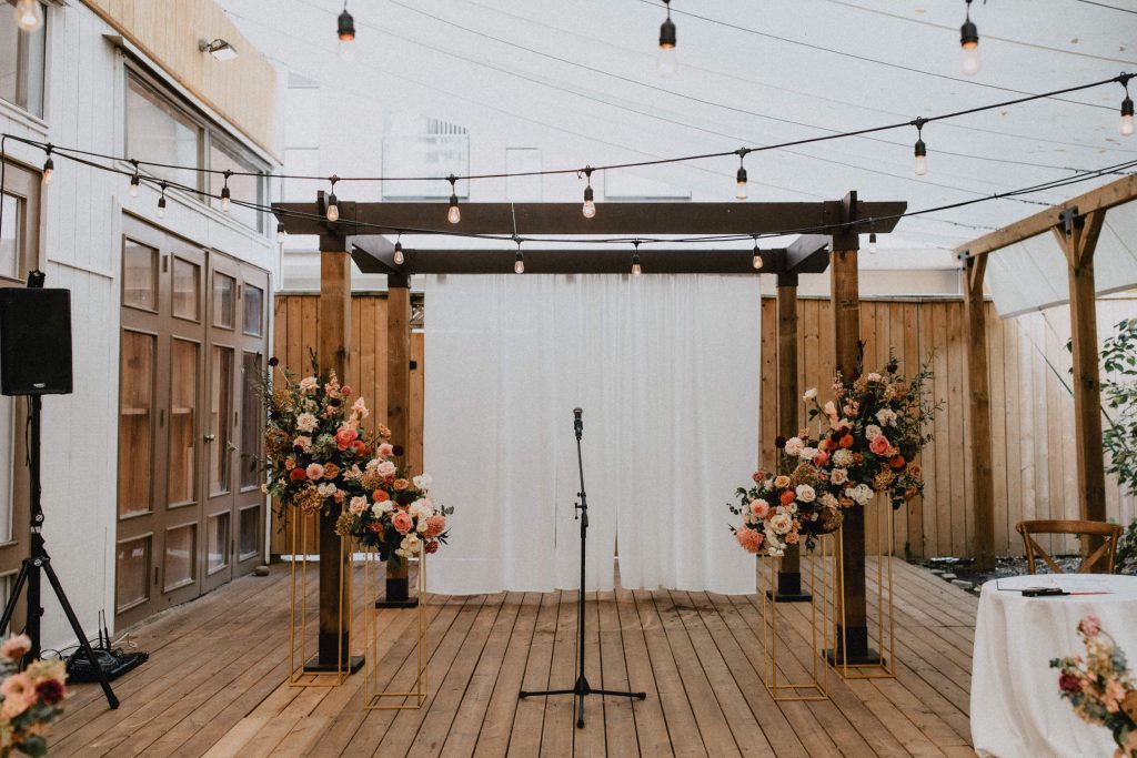 Wooden Alter with warm toned floral arrangements and string lights - Autumn Micro Wedding at Berkeley Fieldhouse