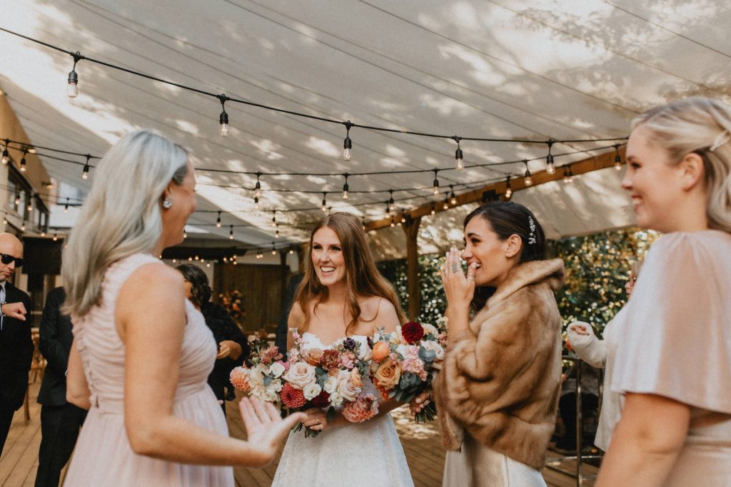Bride laughs with bridesmaids - Autumn Micro Wedding at Berkeley Fieldhouse